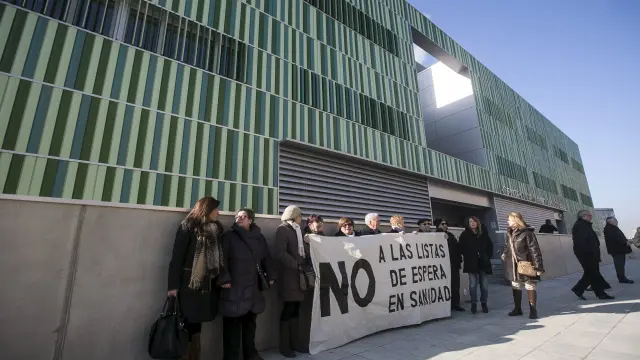 Un grupo de miembros de la Asociación de Vecinos de la Almozara ha recibido a Rudi y Oliván con una pancarta en la que se leía 'No a las listas de espera'.