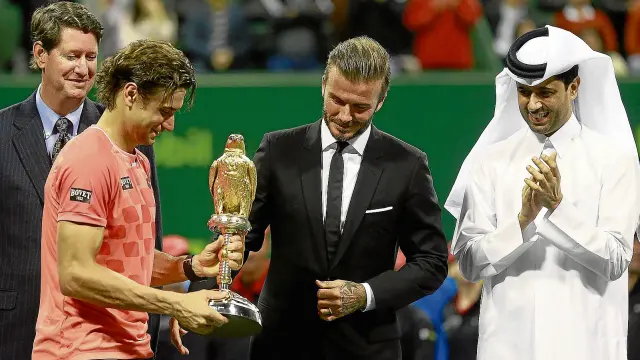 David Ferrer recibe de manos de David Beckham el trofeo de ganador del torneo de Doha.