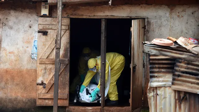 Trabajadores sanitarios de Sierra Leona trasladan el cuerpo sin vida de un paciente de ébola en Freetown (Sierra Leona).