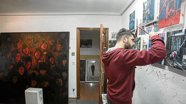 Víctor Solana pinta sus nuevos cuadros en el comedor del piso que utiliza como estudio.