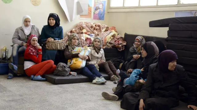 Ciudadanos sirios llegan a un centro improvisado de evacuación en Damasco
