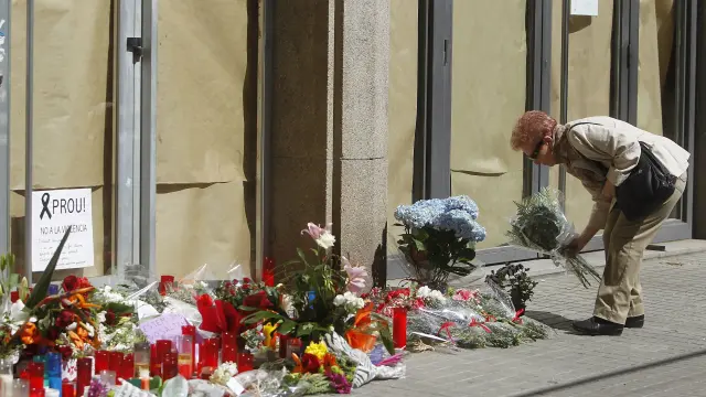 Una mujer deja flores a las puertas del instituto Joan Fuster de Barcelona