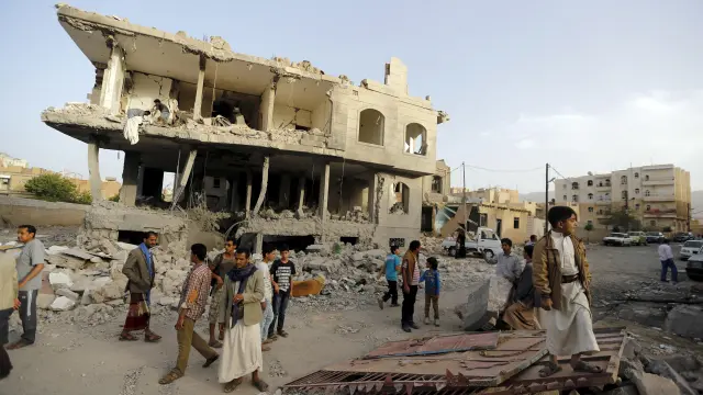 Un grupo de gente espera en el lugar de ataque en Sanaa.