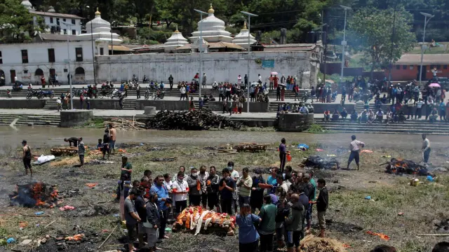 Ciudadanos rezando tras la incineración de cuerpos.
