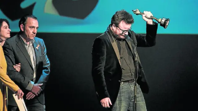 Ignacio Estaregui levanta emocionado su Simón al mejor largometraje, junto a su mujer Gloria Sendino y Jaime García Machín.
