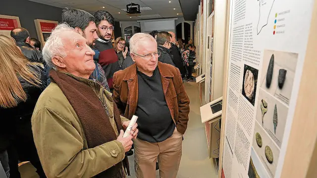 Vecinos de Almudévar observan la exposición sobre su historia en el nuevo centro.
