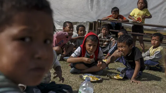 Varios niños de Nepal comiendo en la calle.