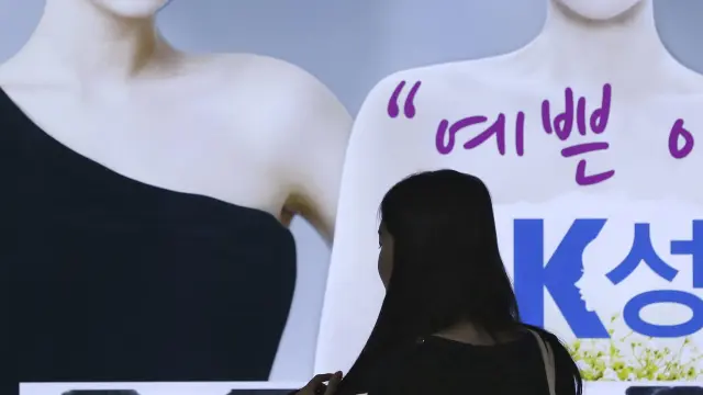 Una mujer observa un cartel publicitario en el metro, en Seúl.