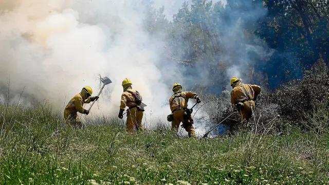Imagen de archivo de un retén antiincendios en la extinción de un fuego en el entorno de Barbastro.