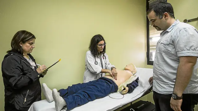 Una alumna de Medicina explora el abdomen a un maniquí en la prueba de habilidades clínicas.