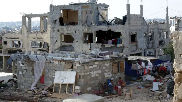 Unos niños juegan en el exterior de una casa destruida en Gaza