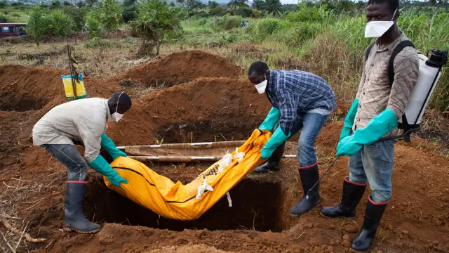 Varios voluntarios con el traje de seguridad entierran el cuerpo de un fallecido en Waterloo, al sureste de Freetown, en una imagen de archivo.