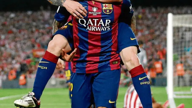 Leo Messi celebra uno de sus goles sobre las espaldas de Alves.