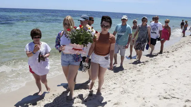 Varios turistas depositan flores en memoria de las víctimas en la playa situada frente al hotel Imperial Marhaba de Susa.