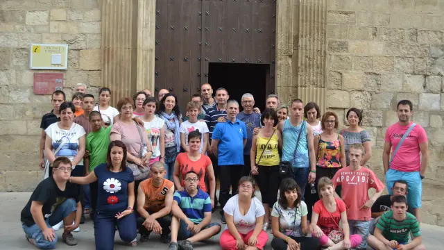 El alcalde y la concejal de Cultura de Fonz junto a los niños con síndrome de Down de Huesca, Italia y Bulgaria y sus responsables en la puerta del Ayuntamiento.