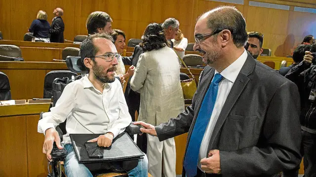 El líder de Podemos, Pablo Echenique, y el del PSOE, Javier Lambán, conversan en las Cortes.