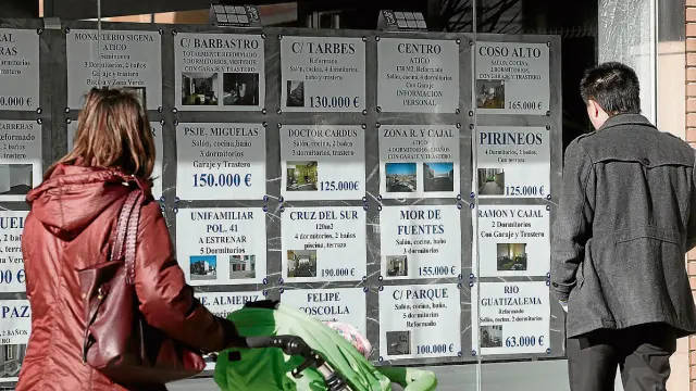 Imagen de 2013 de varias personas consultando ofertas en una inmobiliaria de Huesca.