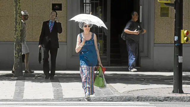 Una mujer se protegía ayer del sol con una sombrilla en el paseo de María Agustín.