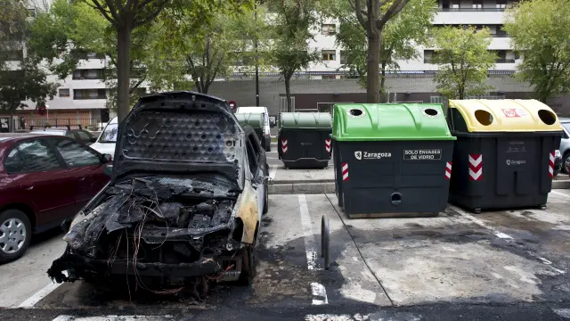 Un coche, afectado por el incendio de un contenedor, en Zaragoza