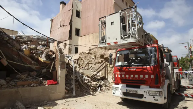 Un camión de Bomberos, junto al edificio derruido