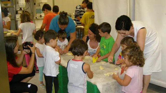 Los niños trabajan la masa en la panadería turiasonense.