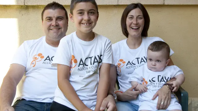 El pequeño Hugo (d), de 16 meses, junto a sus padres y su hermano vestidos con las camisetas de la asociación Actays.