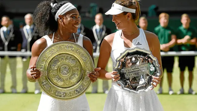 Serena Williams y Garbiñe Muguruza se sonríen en la entrega de trofeos tras la final de Wimbledon.