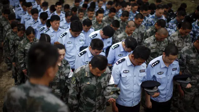 Soldados, policías y paramilitares asisten a un funeral por las víctimas de la explosión de Tianjin.