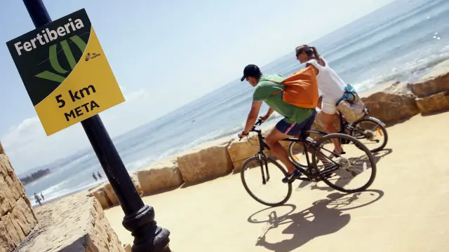 Dos turistas circulan por el paseo marítimo de Puerto Banús por donde este sábado pasará la Vuelta.