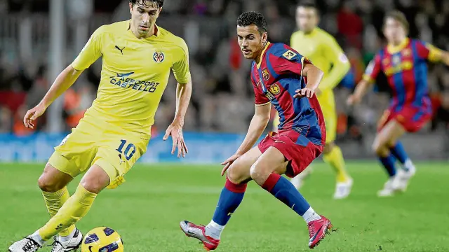 El aragonés Cani protege el balón ante Pedro, durante un partido ante el Barcelona.