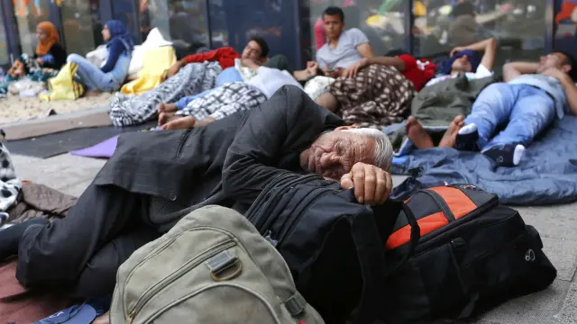 Varios inmigrantes descansan junto a una estación de tren Budapest