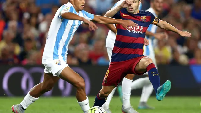 Iniesta lucha el balón con Juanpi, durante el partido de la segunda jornada del Campeonato de Liga.