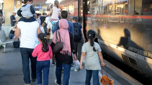 Varios refugiados procedentes de Hungría se suben a un tren con destino a Alemania.