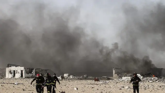 Un grupo de bomberos trabajan sobre el terreno donde ha tenido lugar la explosión.