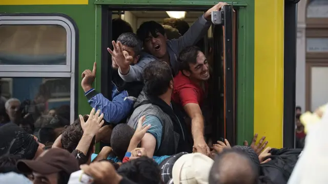 Varios inmigrantes intentan subirse a un tren en la estación Keleti de Budapest.