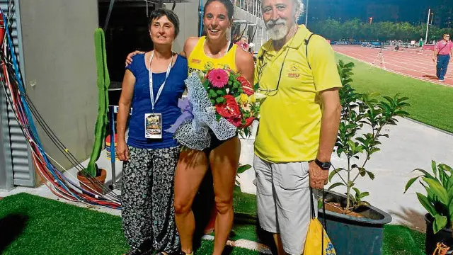 Laura Ginés, en el centro, junto a sus entrenadores, Esther Lahoz y Pedro Pablo Fernández.