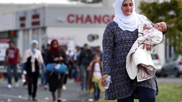 Una mujer camina con su bebé en la zona fronteriza entre Hungría y Austria