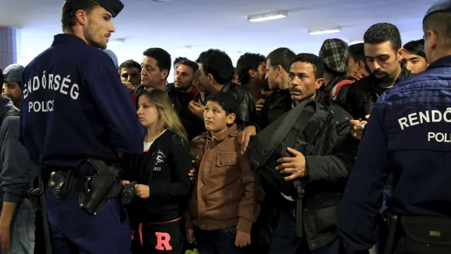 Refugiados sirios y de otros países esperan en el lado serbio para poder cruzar la frontera con Hungría.