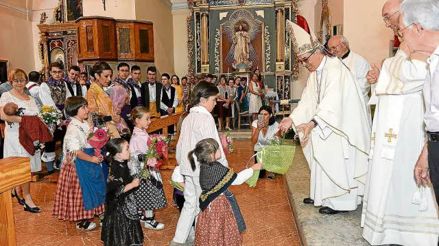 El cardenal Santos Abril recibe las ofrendas de un grupo de niños en la iglesia de Alfambra.