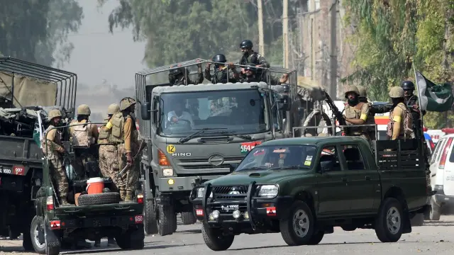 Varios soldados pakistaníes en torno a la base aérea de Badaber tras el ataque.