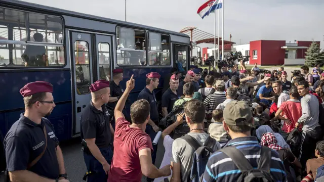 La Policía húngara vigila a un grupo de refugiados este viernes en la frontera entre Hungría y Croacia.