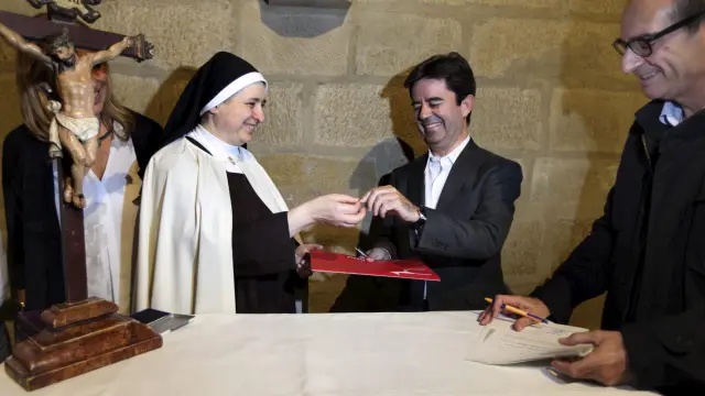 El alcalde de Huesca, Luis Felipe, paga un céntimo de euro a la superiora del convento de las Miguelas.