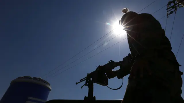 Un oficial de seguridad afgano vigila en un puesto de control en Herat