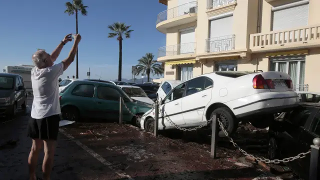 Un hombre fotografía coches amontonados por las inundaciones en Cannes.