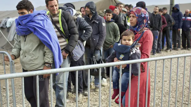 Refugiados hacen fila para entrar a un campamento en la frontera Serbia.