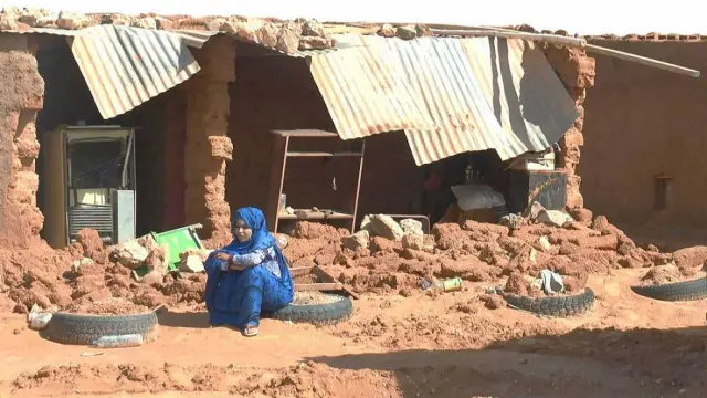 Un mujer sentada junto a los escombros provocados por las lluvias en un campo saharau