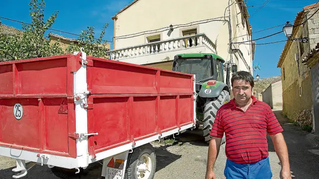 Javier Barcelona, en Tierga, junto al tractor y el remolque que le robaron y que ha podido recuperar.