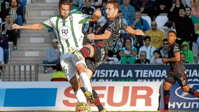 Manolo, que vivió un partido especial contra el club en el que se formó, pugna por el balón con el aragonés Luso.