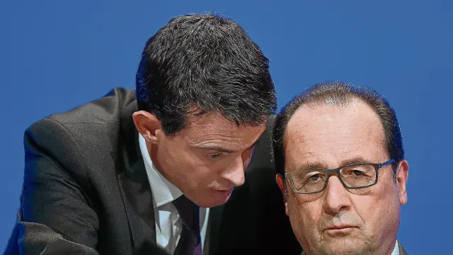 François Hollande escucha atentamente al primer ministro francés, Manuel Valls.
