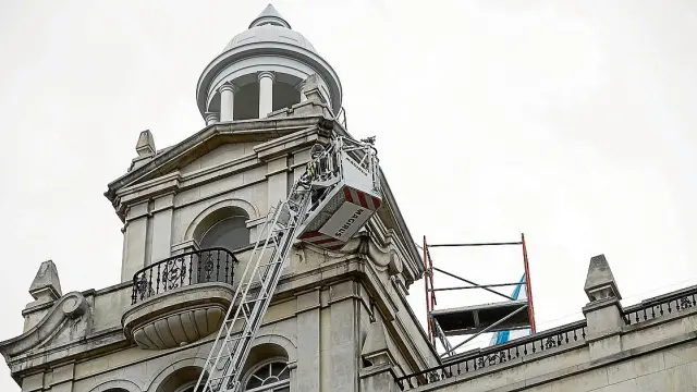 Los bomberos tuvieron que anclar un andamio en el tejado de un edificio de la plaza de España.